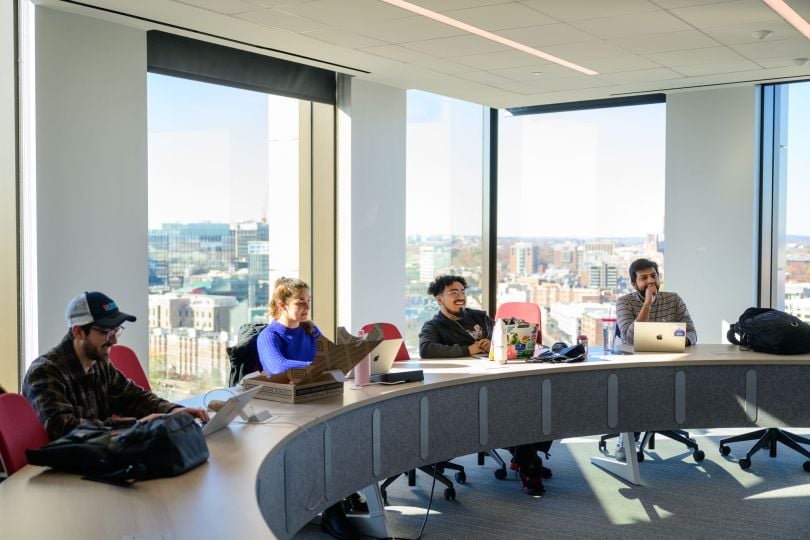 CarGurus employees listen to a speaker in the company's office